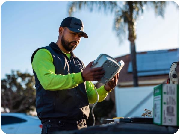 Technician holding a Rain Bird irrigation system controller