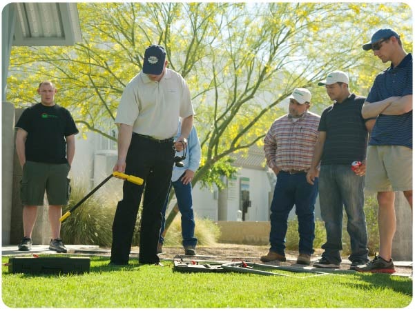 Instructor explaining various components of an irrigation system to five trainees