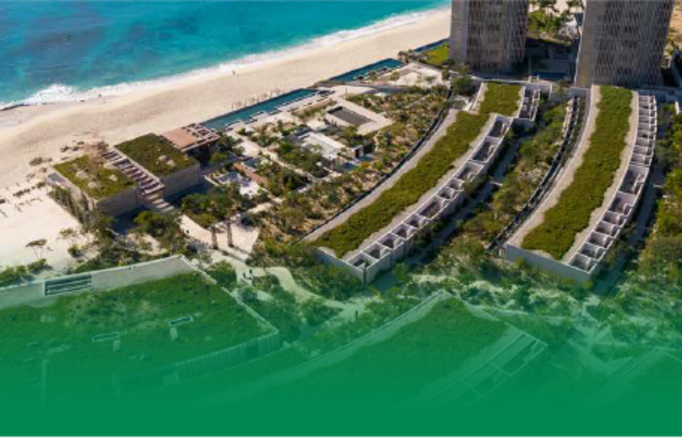 Overhead view of the Solaz Resort in Cabo San Lucas Mexico with tall hotel buildings, greenscapes and the ocean.